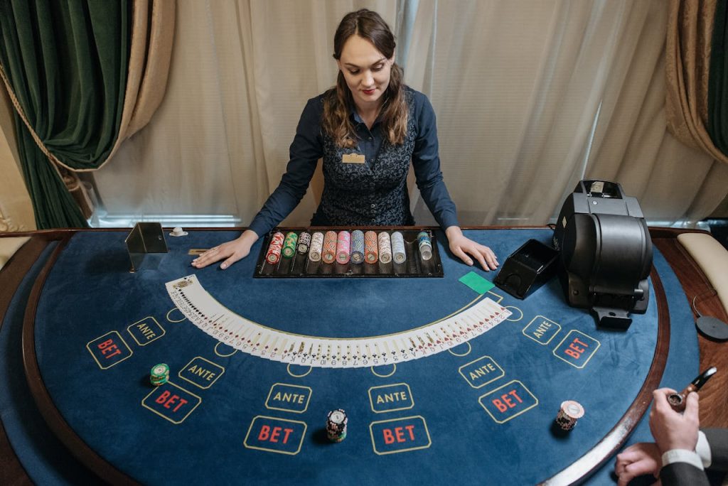Professional female casino dealer managing a gaming table with chips and cards in a luxurious setting.
